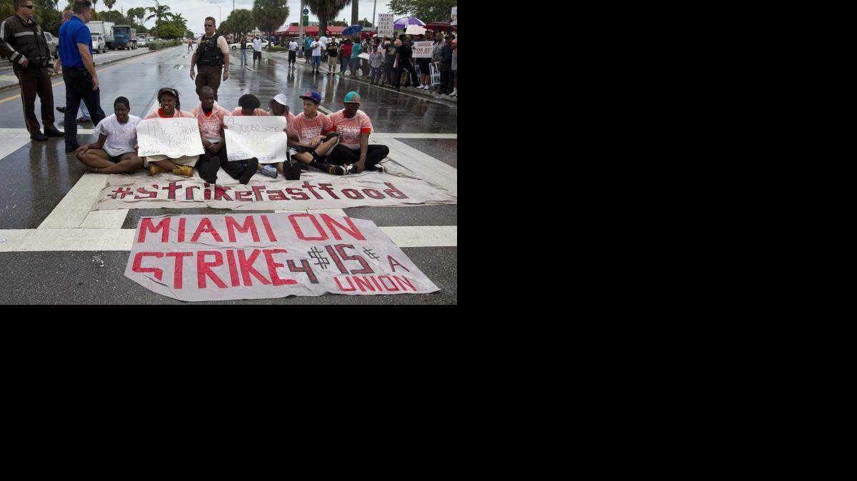 
Striking fast-food workers hold picket signs on Sept. 4, 2014, in Miami as they protest in front of restaurants where they picketed during a nationwide protest in favor of a $15 an hour minimum wage.
