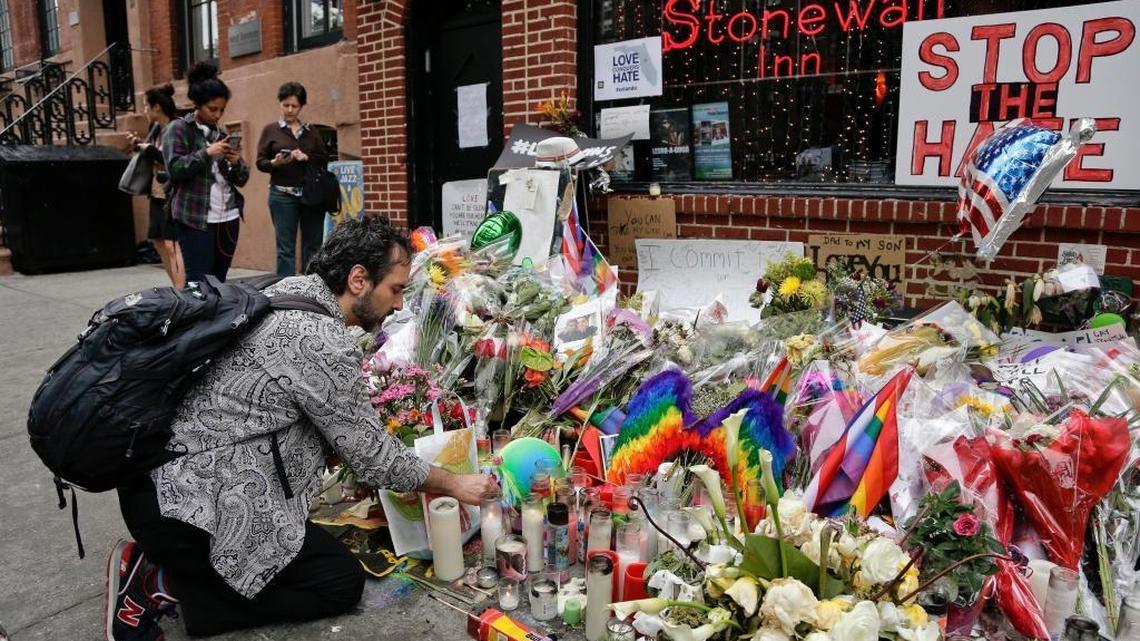 In this June 16, 2016, file photo, a man lights candles on a memorial outside the Stonewall Inn in New York City.
