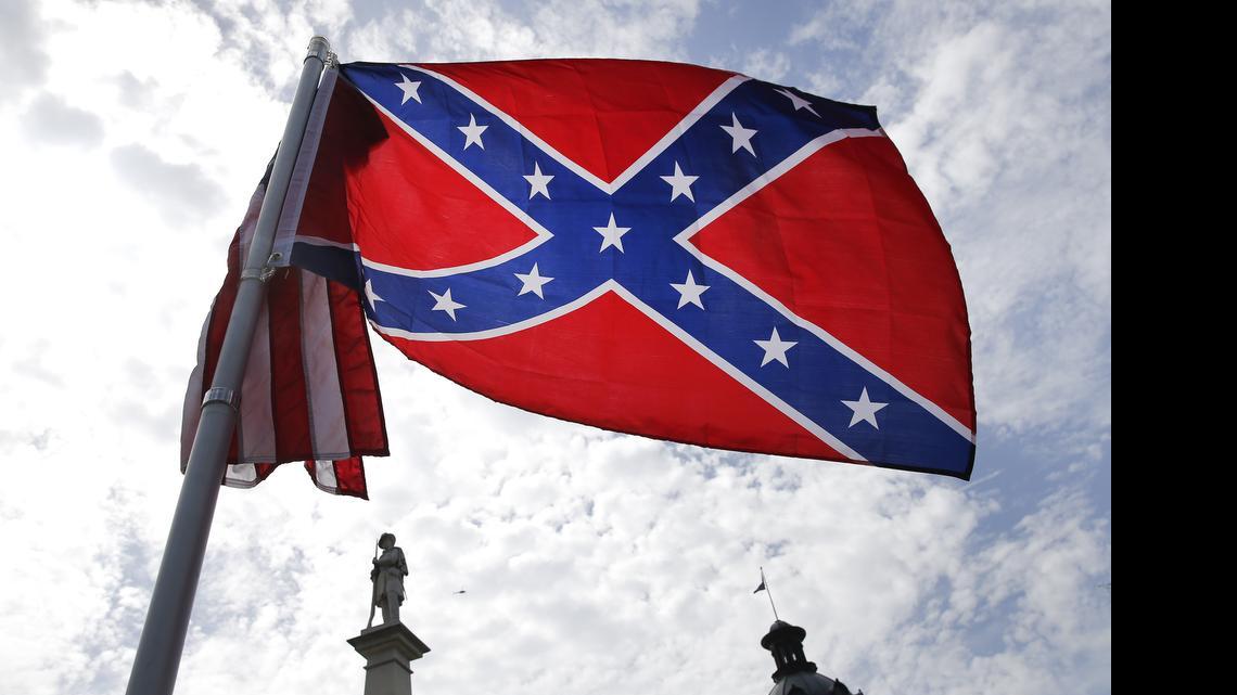 
A protester waves a Confederate battle flag in front of the South Carolina statehouse. More than 50 years after the state raised the flag at its statehouse to protest the civil rights movement, the rebel banner is scheduled to be removed Friday morning during a ceremony.
