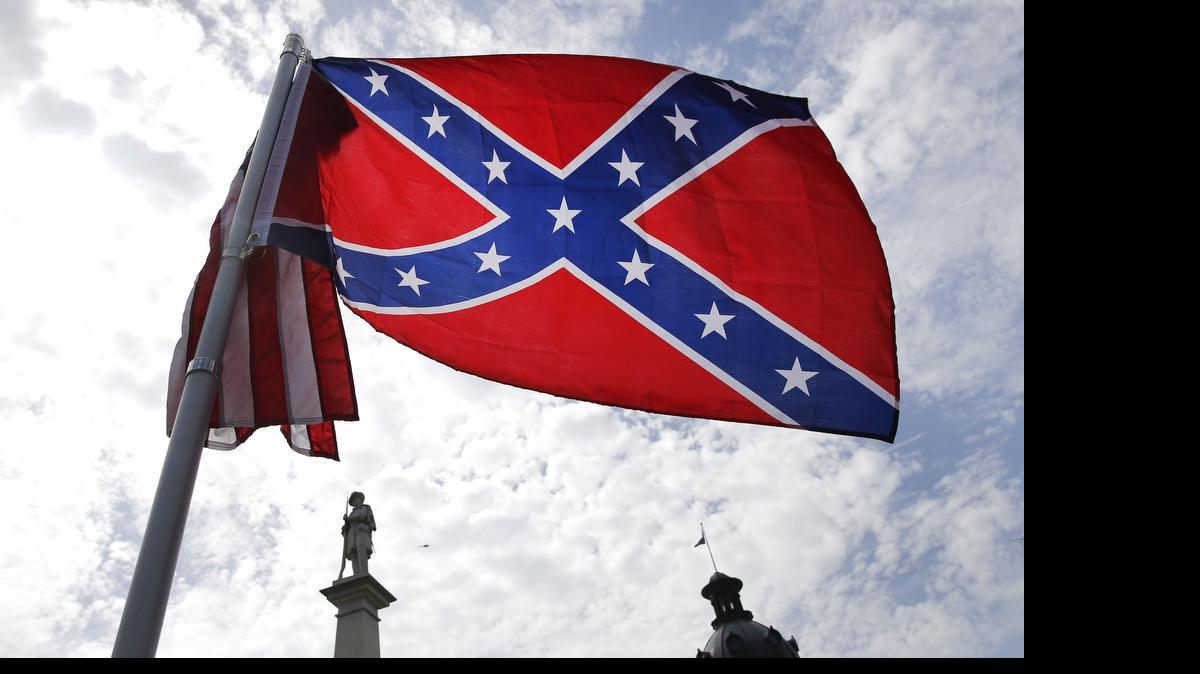 
A protester waves a Confederate battle flag in front of the South Carolina statehouse. More than 50 years after the state raised the flag at its statehouse to protest the civil rights movement, the rebel banner is scheduled to be removed Friday morning during a ceremony.
