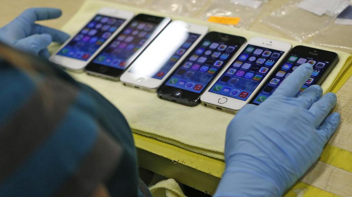 iPhones by the hundreds are lined up after being repaired at refurbishment center in Grapevine, Texas. The U.S. and tech companies are battling over how private your smartphone should be.