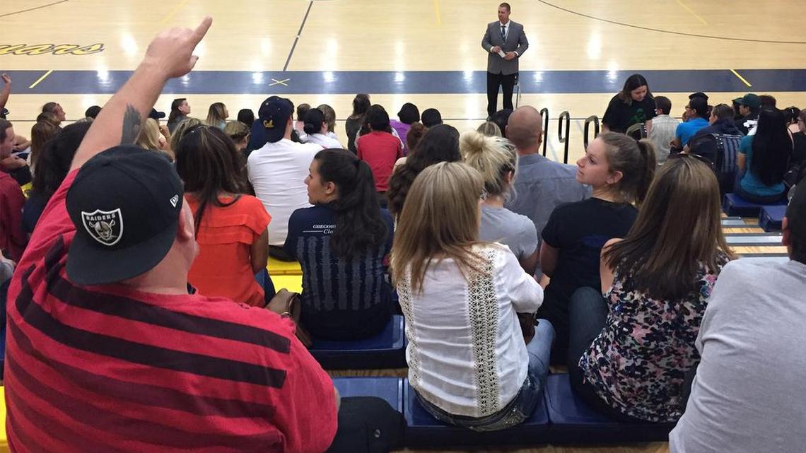 Gregori High School Principal Brad Goudeau talks to families about problems on the senior trip to Disneyland.