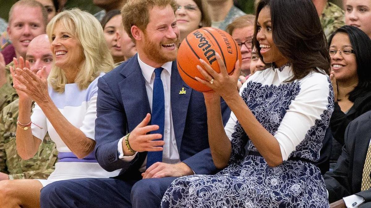 First lady Michelle Obama, accompanied by Jill Biden, left, reacts as Britain's Prince Harry hands her the basketball as the conclusion of a game of wheelchair basketball by wounded servicemen and veterans at Fort Belvoir military base, Wednesday, Oct. 28, 2015 in Fort Belvoir, Va. The event was held in support of the Invictus Games Orlando 2016.