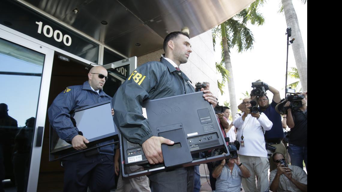 
Federal agents load a van with boxes and computers taken from the headquarters of the Confederation of North, Central America and Caribbean Association Football (CONCACAF) on Wednesday, May 27, 2015, in Miami Beach, Fla. Swiss prosecutors opened criminal proceedings into FIFA's awarding of the 2018 and 2022 World Cups, only hours after seven soccer officials were arrested Wednesday in Zurich, Switzerland. 
