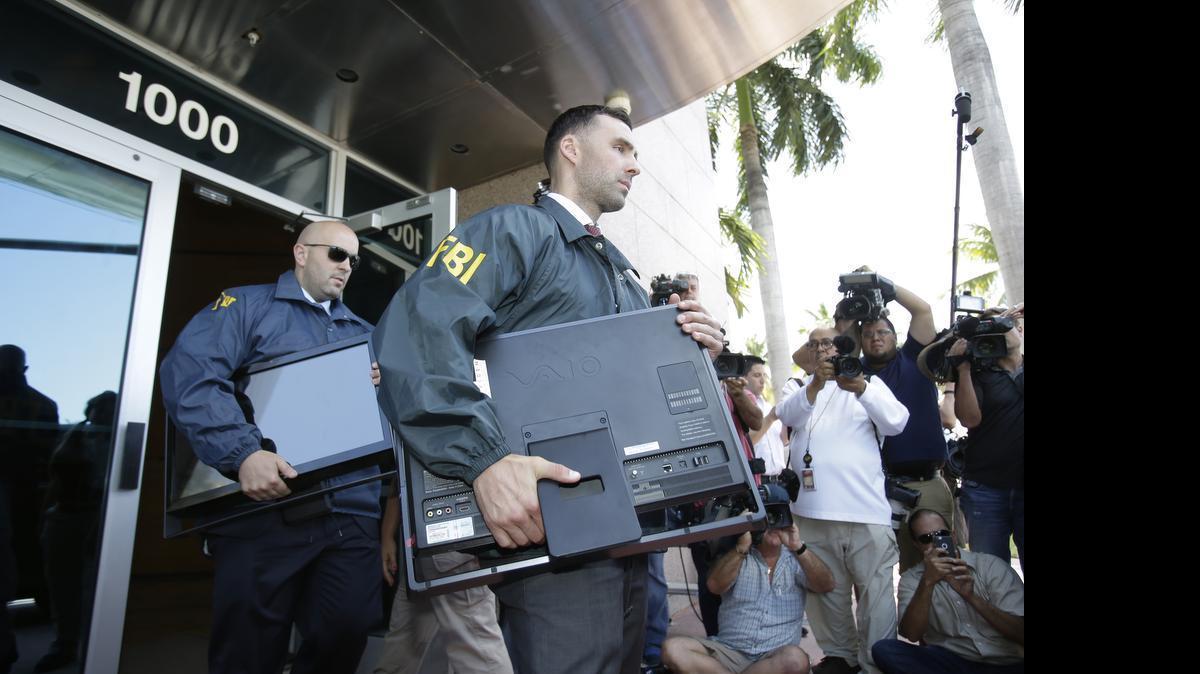 
Federal agents load a van with boxes and computers taken from the headquarters of the Confederation of North, Central America and Caribbean Association Football (CONCACAF) on Wednesday, May 27, 2015, in Miami Beach, Fla. Swiss prosecutors opened criminal proceedings into FIFA's awarding of the 2018 and 2022 World Cups, only hours after seven soccer officials were arrested Wednesday in Zurich, Switzerland. 
