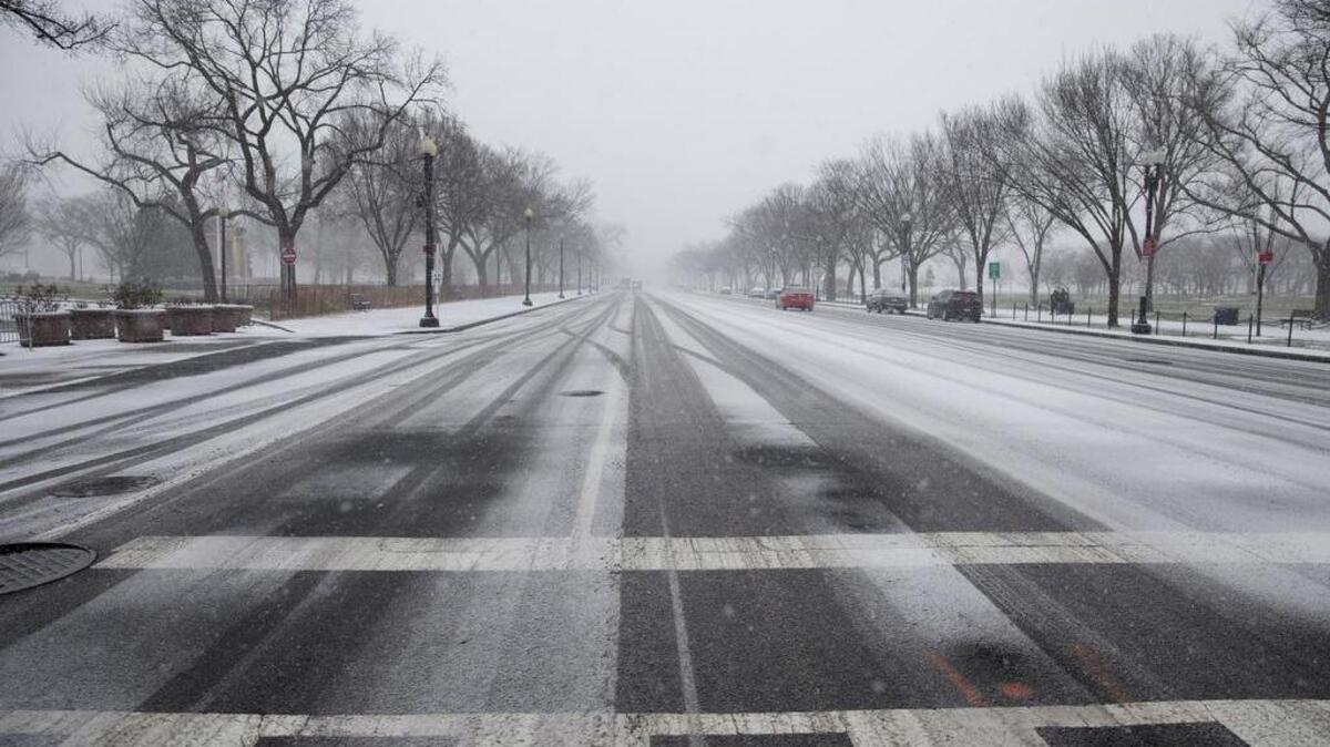 Constitution Avenue is seen almost empty of cars as snow begins to blanket Washington, Friday, Jan. 22, 2016. A blizzard menacing the Eastern United States started dumping snow in Washington, Virginia, Tennessee and other parts of the South on Friday as millions of people in the storm’s path prepared for icy roads, possible power outages and other treacherous conditions.