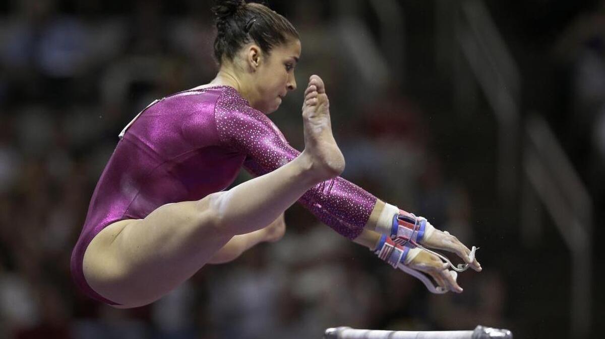 Aly Raisman reaches for the top bar on the uneven bars during the preliminary round of the women's Olympic gymnastics trials, Friday, June 29, 2012, in San Jose, Calif.