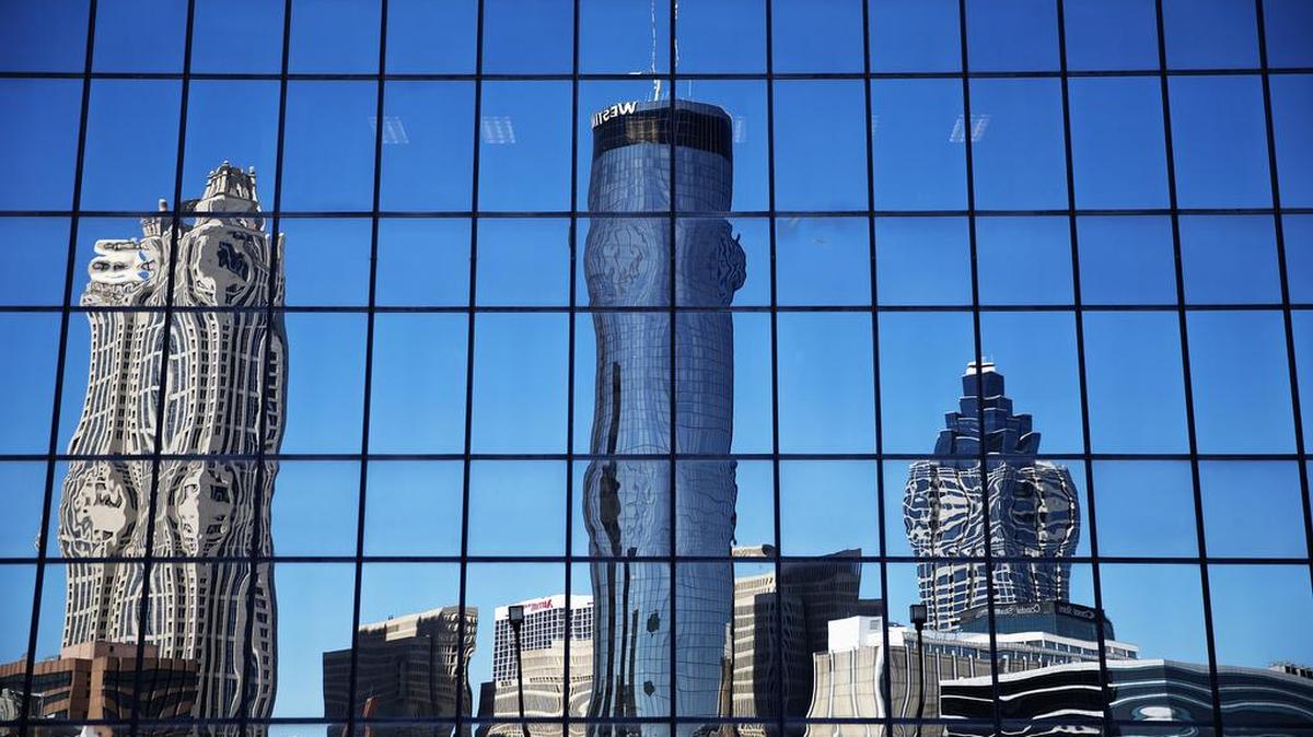 The Westin hotel, center, is reflected along with other downtown buildings in the windows of an office tower in Atlanta, Wednesday, Sept. 28, 2016. An exit button inside the Westin hotel where a worker was found dead failed to work during an inspection, trapping multiple people who had to beat on the door to alert someone to let them out, a medical examiner found.