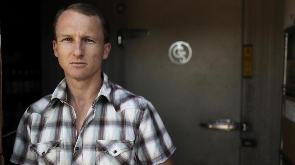 Aaron Rabinowitz poses for a picture in front of the freezer where his father died, at the family’s Gelato Vero Caffe in San Diego. Rabinowitz’s father, Henry Rabinowitz, died inside the freezer in 2007.