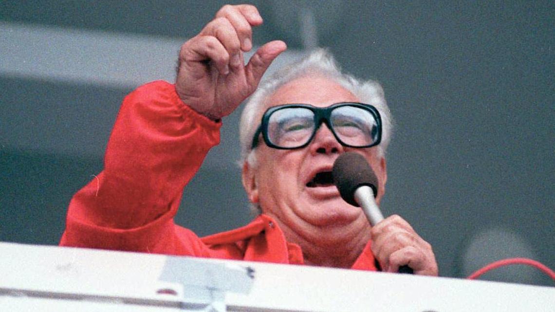 FILE - In this July 21, 1989 file photo Chicago Cubs' broadcaster Harry Caray sings "Take Me Out To The Ballgame" during the seventh inning stretch at Chicago's Wrigley Field. Brewer Anheuser-Busch honored the legendary sportscaster, who died in 1998 having not seen his beloved Cubbies make it to the World Series, with a video that had him calling the end of Game 7, with the Cubs defeating the Cleveland Indians in an extra-inning 8-7 nail biter. The brewer also resuscitated 1984 Budweiser ad in which the Bud pitch man, and consumer, caught a cold one launched into the Wrigley Field bleachers using a net.