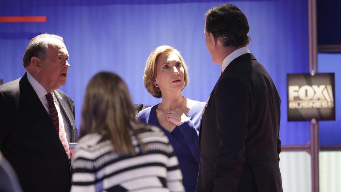 Republican presidential candidates Carly Fiorina, Rick Santorum and Mike Huckabee talk during a commercial break in the early GOP debate on Fox Business Network at the North Charleston Coliseum, Thursday, Jan. 14, 2016, in North Charleston, S.C.