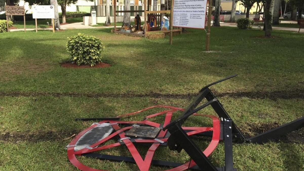 A satanic pentagram erected by atheist Preston Smith lies damaged in Boca Raton, Fla. on Tuesday, Dec. 20, 2016. Smith erected the pentagram in the city-owned Sanborn Square earlier this month to protest a Nativity scene there. Vandals apparently dragged down the 300-pound sculpture using a chain attached to a vehicle.