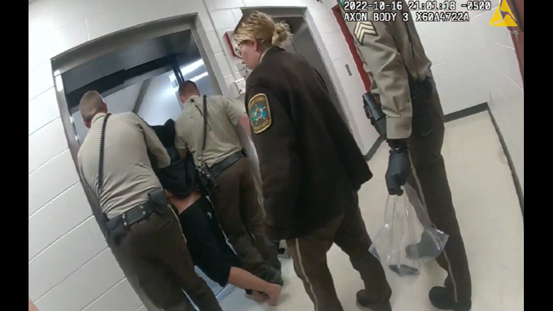 Jail staff carrying Nickolas Daniel Norberg into an elevator.