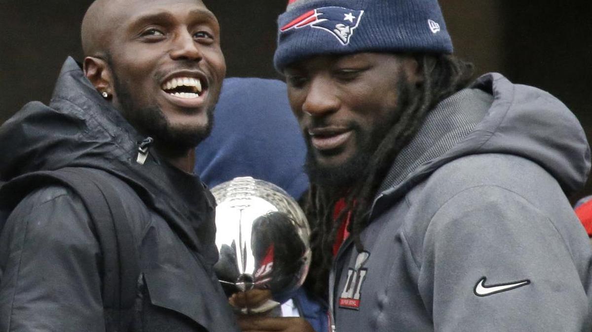 New England Patriots safety Devin McCourty, left, and running back LeGarrette Blount hold a Super Bowl trophy during a rally Tuesday, Feb. 7, 2017, in Boston, to celebrate Sunday's 34-28 win over the Atlanta Falcons in the NFL Super Bowl 51 football game in Houston.