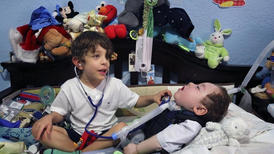 Adrian Quesada, 5, left, plays doctor with his twin brother, Alejandro Quesada, right, who is ailed with the diagnosis of cortical visual impairment, bilateral retinopathy of prematurity, brain atrophy and optic atrophy, inside his out dated crib on Thursday, December 21, 2017. Quesada is in need of a new medical bed, a special car chair, and other items due to medical condition.