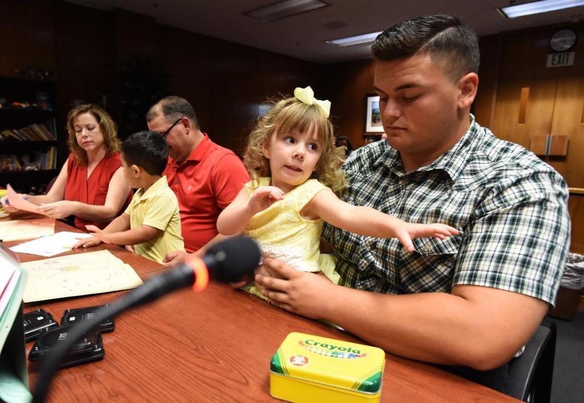 Carson Petersen, 18, tries to keep his new 4-year-old sister Kaylynn Petersen occupied in a Fresno courtroom as his adoptive parents, Renee and Tex Petersen, do the same with son, Joshua Petersen, 2, before the adoption proceedings at Fresno County Superior Court.