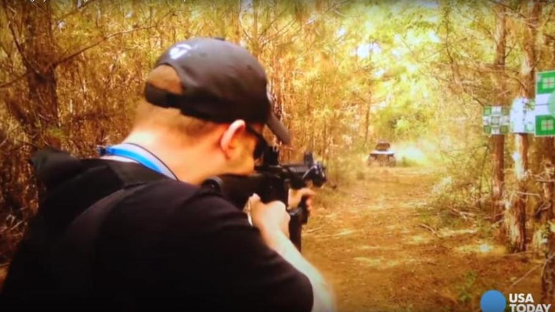 As seen in this screencapture from a video posted by USA Today, David Pressley takes aim at the lawnmower packed with explosives.