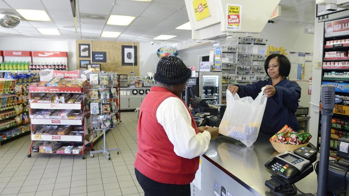 Elizabeth Tate is helped by Donna Boulware, sister of the proprietor, Victor Boulware. Lewis Efird, 42, president of United Oil of the Carolinas and Victor Boulware, 52, owner of the Lake Wylie Mini Mart in Clover, S.C. are concerned that a possible move of the state line will have a negative affect on the business.