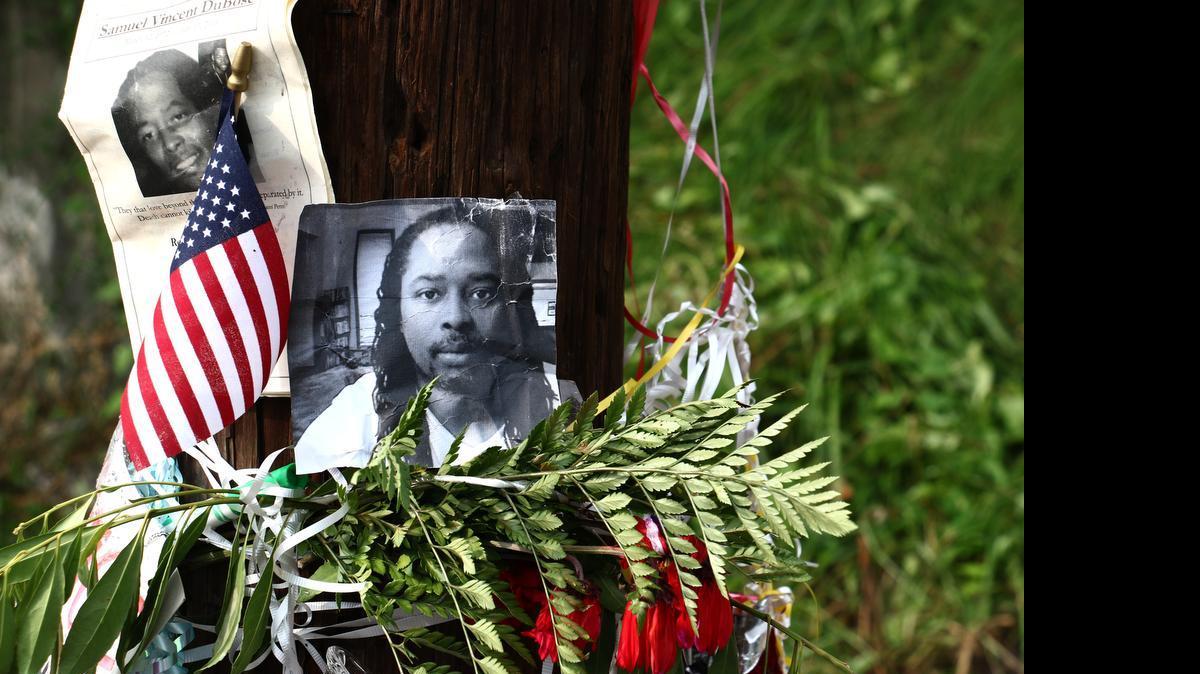 
Photos of Samuel DuBose hang on a pole at a memorial, Wednesday July 29, 2015 in Cincinnati, near where he was shot and killed by a University of Cincinnati police office. Murder and manslaughter charges were announced against University of Cincinnati Police Officer Ray Tensing for the traffic stop shooting death of DuBose. 
