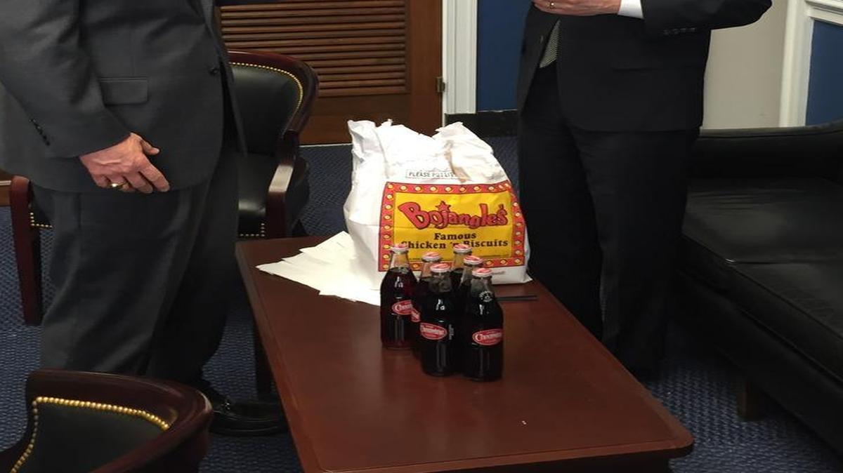 North Carolina Rep. Robert Pittenger, left, pays off a Super Bowl bet to Colorado Rep. Mike Coffman.