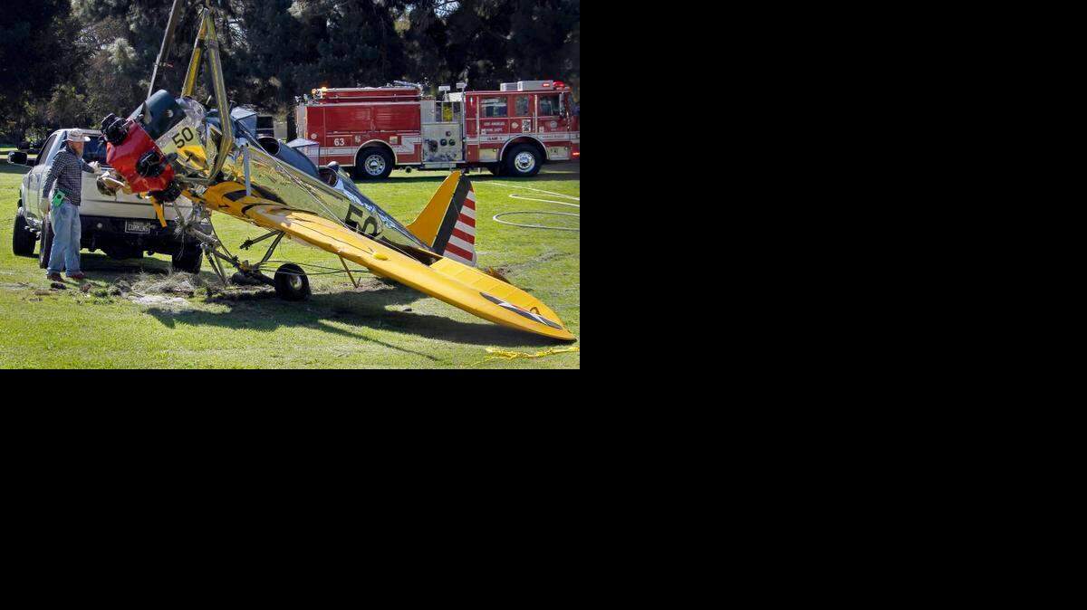 
The World War II-era trainer airplane that actor Harrison Ford crash-landed Thursday is removed from Penmar Golf Course in the Venice area of Los Angeles, Friday, March 6, 2015. 
