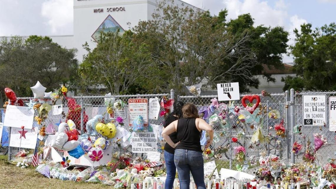 Mourners bring flowers as they pay tribute at a memorial for the victims of the shooting at Marjory Stoneman Douglas High School on Sunday, Feb. 25, 2018. There was an “open house” for parents and students who wanted to return to the school for the first time since 17 students and teachers were killed on Feb. 14.
