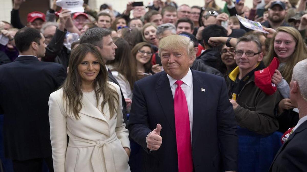 Republican presidential candidate Donald Trump gives a thumbs-up as he and his wife, Melania, pause for photos at a rally Sunday, Jan. 31, 2016, in Council Bluffs, Iowa.