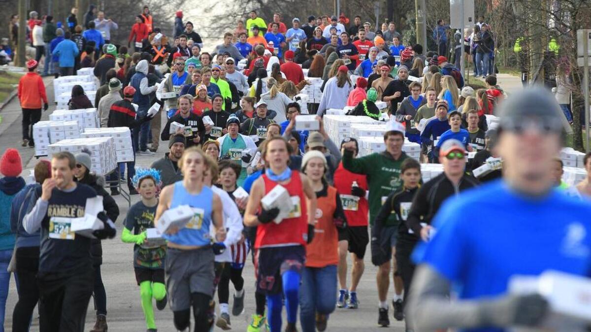 Some of the thousands of runners head down N. Person St. after picking up their doughnuts during the 12th annual Krispy Kreme Challenge race in Raleigh on Saturday.