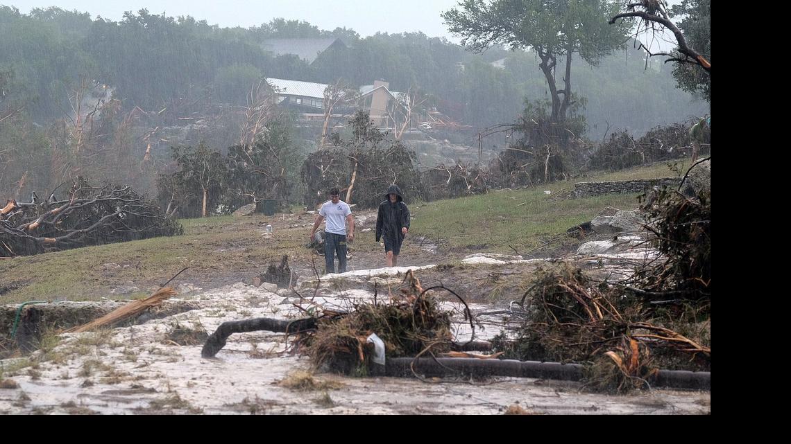 
Hudson Doty, 18, left, and Grant Guzal, 17, right, walk along the bank of the Blanco River near the foundation and stilts of the Carey family home on Deer Crossing Lane, in Wimberley, Texas, on Monday, May 25, 2015. The Carey family and McComb family, from Corpus Christi, Texas, have been missing since after their home was swept away by the Blanco River early Sunday morning. 
