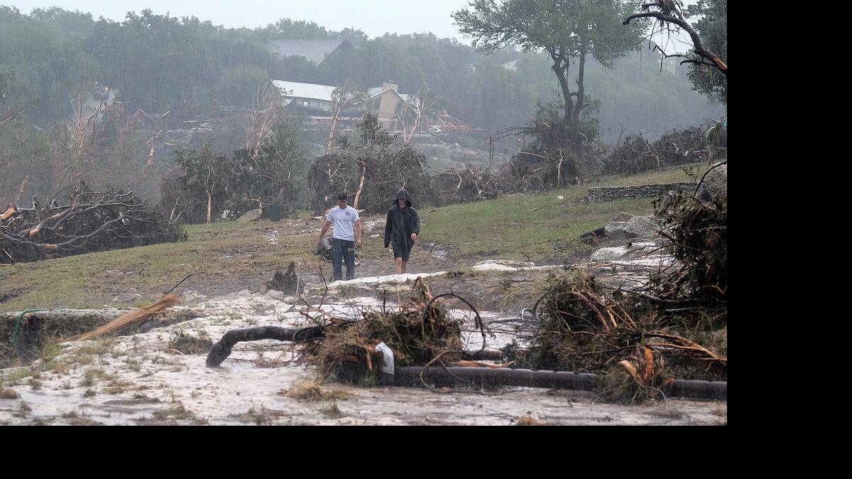 
Hudson Doty, 18, left, and Grant Guzal, 17, right, walk along the bank of the Blanco River near the foundation and stilts of the Carey family home on Deer Crossing Lane, in Wimberley, Texas, on Monday, May 25, 2015. The Carey family and McComb family, from Corpus Christi, Texas, have been missing since after their home was swept away by the Blanco River early Sunday morning. 
