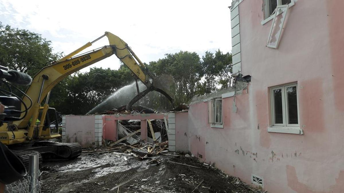 A bulldozer demolishes the waterfront mansion formerly owned by Colombian drug lord Pablo Escobar, Tuesday, Jan. 19, 2016, in Miami Beach, Fla.