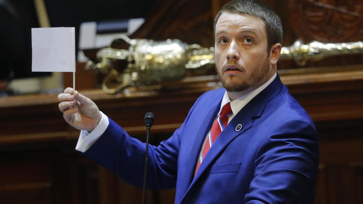 Rep. Christopher Corley, R-SC, shows his frustration by waving a white flag of surrender during debate over a Senate bill calling for the Confederate flag to be removed from the Capitol grounds Wednesday, July 8, 2015, in Columbia, S.C.