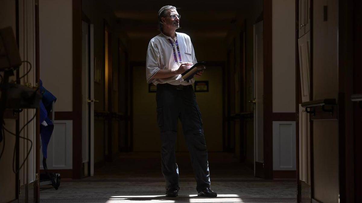Craig Phillips, an end-of-life doula with Gilchrist Hospice Care in Baltimore, pauses before entering the room of a dying patient.