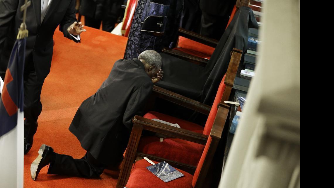 
A parishioner prays at the empty seat of the Rev. Clementa Pinckney at the Emanuel A.M.E. Church on Sunday, June 21, 2015, in Charleston, S.C., four days after a mass shooting claimed the lives of Pinckney and eight others.
