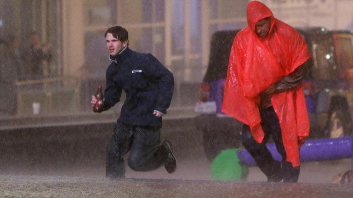 People run as weather sirens sound as a severe storm passes over downtown Dallas, Dec. 26, 2015, in Dallas. The National Weather Service had put the Dallas area was under a tornado warning.