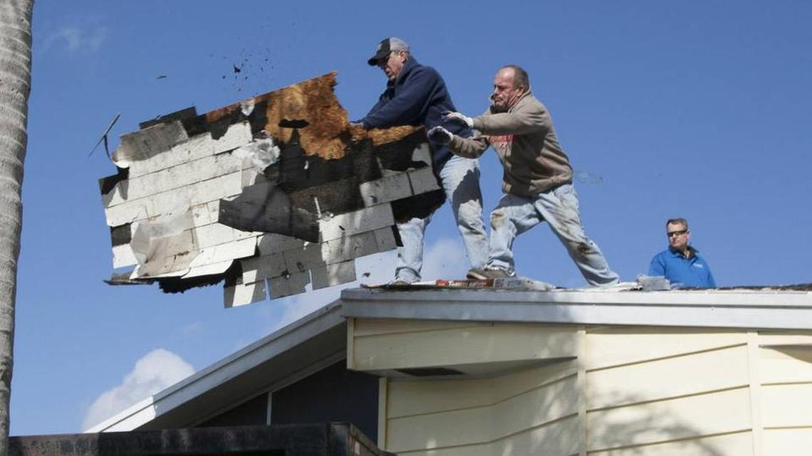 Roofers remove old shingles at Army veteran Harris Nelms' Ellenton home.