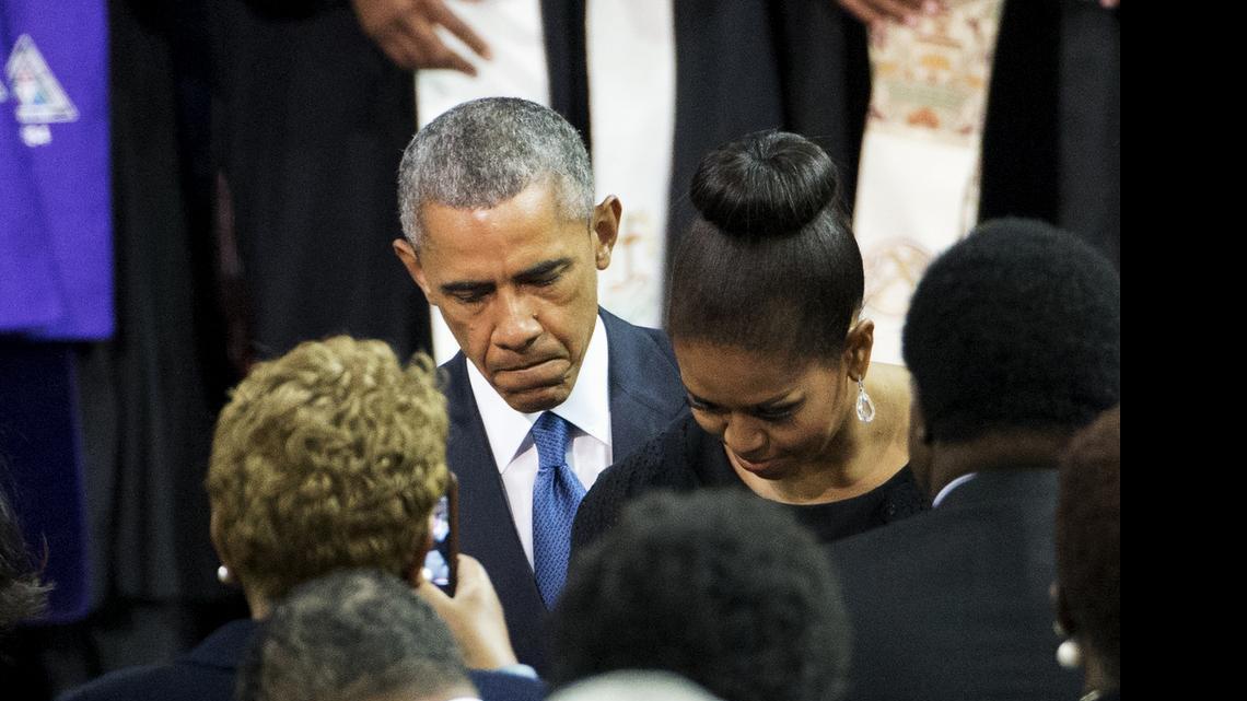 
President Barack Obama and first lady Michelle Obama take their seats at the College of Charleston TD Arena in Charleston, S.C. Friday, June 26, 2015, before the president gave the eulogy during the funeral service for Rev. Clementa Pinckney. The president delivered a passionate discourse on America's racial history Friday in his eulogy for a state senator and pastor, slain along with eight other black churchgoers in what police called a hate crime. 
