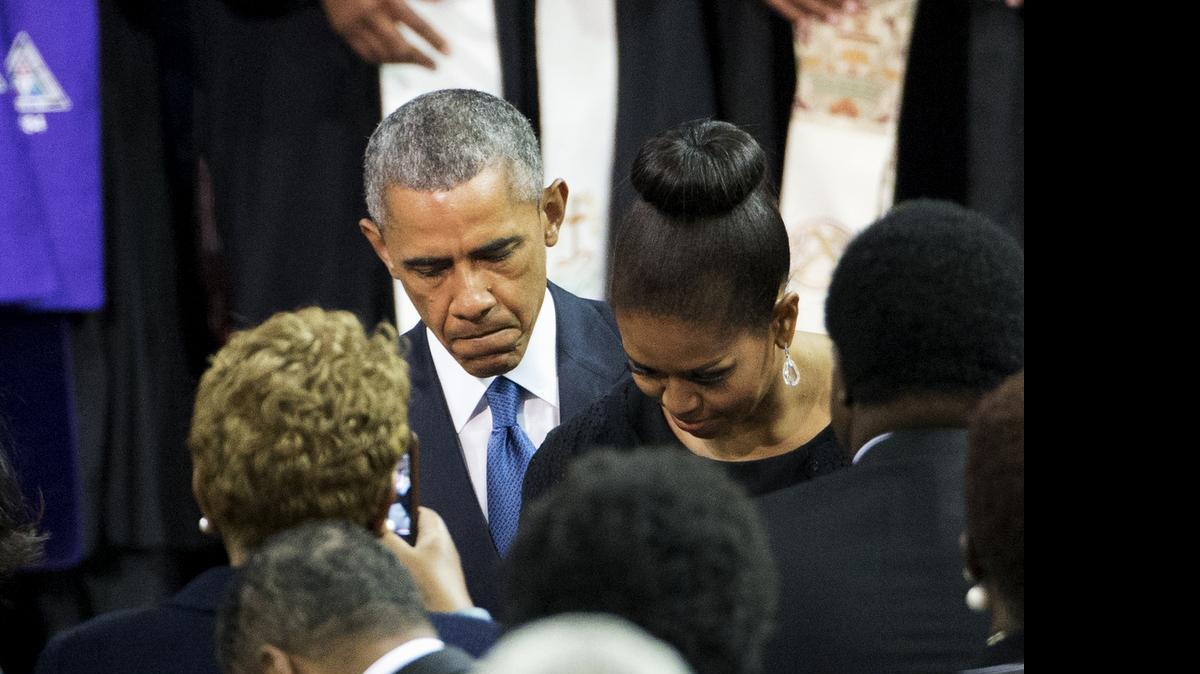
President Barack Obama and first lady Michelle Obama take their seats at the College of Charleston TD Arena in Charleston, S.C. Friday, June 26, 2015, before the president gave the eulogy during the funeral service for Rev. Clementa Pinckney. The president delivered a passionate discourse on America's racial history Friday in his eulogy for a state senator and pastor, slain along with eight other black churchgoers in what police called a hate crime. 

