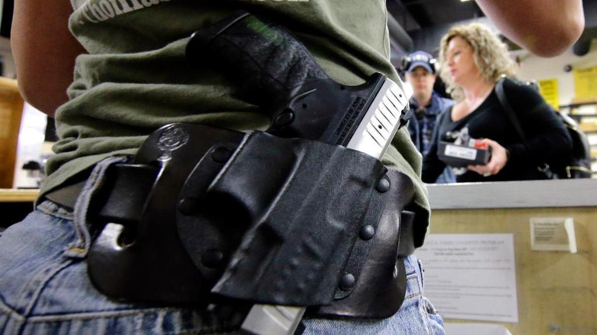 Kayla Brown, left, wears her gun on her hip while working at the Spring Guns and Ammo store Monday, Jan. 4, 2016, in Spring, Texas.