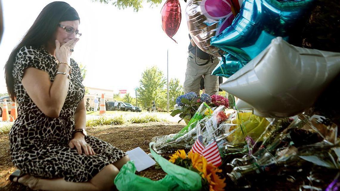 
Pamela Cook of Roanoke, Va., delivers flowers to WDBJ7's Digital Broadcast Center after hearing news of a shooting involving two of the news team members, in Roanoke, Va., Wednesday, Aug. 26, 2015.
