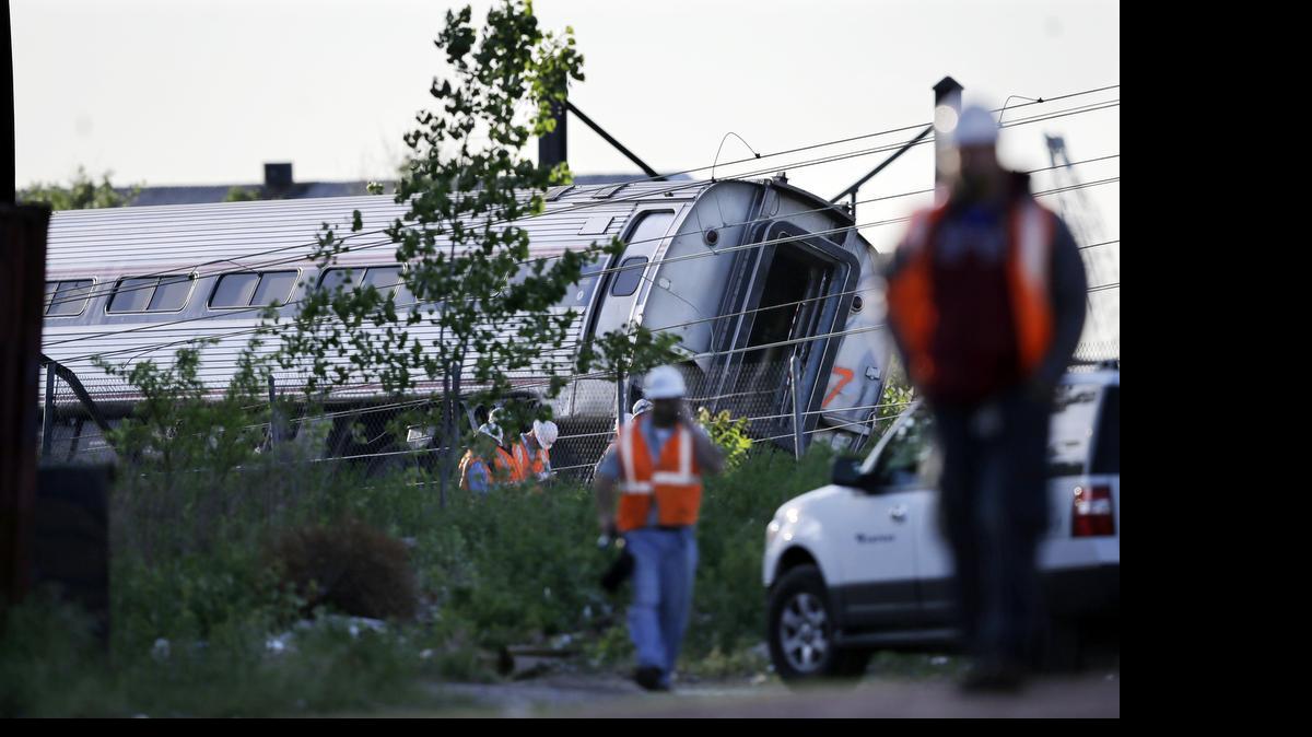 
Emergency personnel walk near the scene of a deadly train wreck, Wednesday, May 13, 2015, in Philadelphia. An Amtrak train headed to New York City derailed and crashed in Philadelphia on Tuesday night. 
