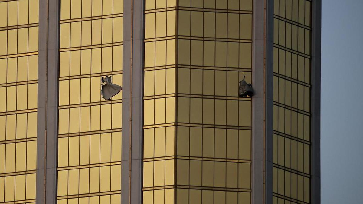 In this Monday, Oct. 2, 2017 file photo, drapes billow out of broken windows at the Mandalay Bay resort and casino on the Las Vegas Strip, following a mass shooting at a music festival in Las Vegas. From two broken-out windows of the resort, Stephen Craig Paddock had an unobstructed view to rain automatic gunfire on the crowd, with few places for them to hide.