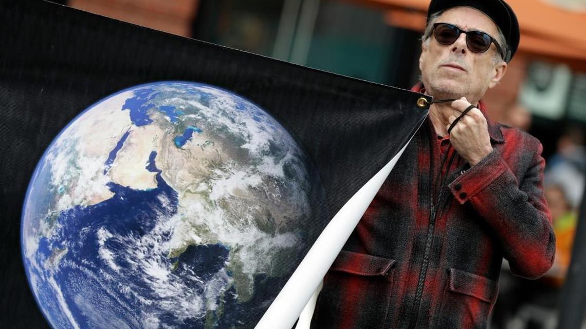 Kurt Wechsler held an image of the earth during a rally by scientists in conjunction with the American Geophysical Union's fall meeting in December. The Trump administration removed references to climate change from the White House web site Friday, a scrubbing that some scientists fear could occur on many federal web sites.