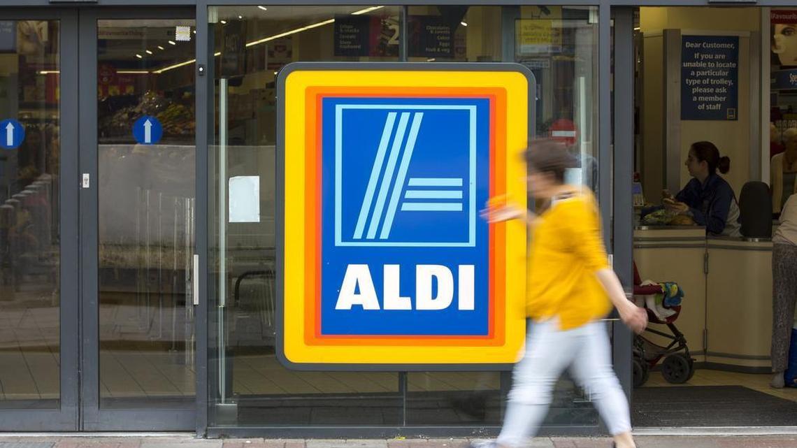 A pedestrian walks past the entrance to an Aldi supermarket store in London.