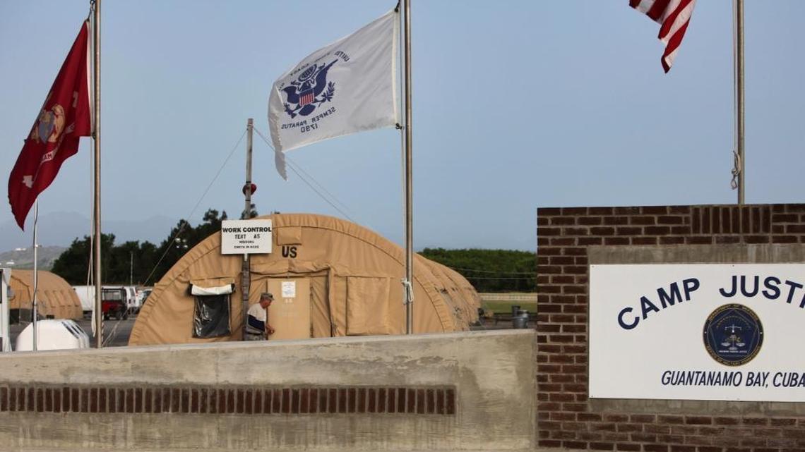 In this July 16, 2009, file photo reviewed by the U.S. military, flags hang above the sign marking the Camp Justice compound, the site of the U.S. war crimes tribunal, at Guantánamo Bay U.S. Naval Base, Cuba.