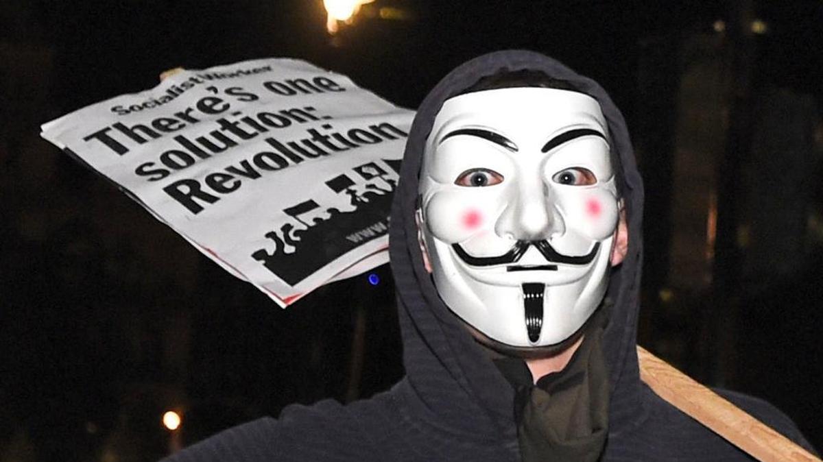 A protester joins others demonstrating near the Houses of Parliament in central London during the Million Mask March bonfire night protest organized by the activist group Anonymous, Nov. 5, 2016. The annual protest is one of many similar marches held worldwide on Nov. 5, broadly aimed at anti-capitalism and pro-civil liberty.