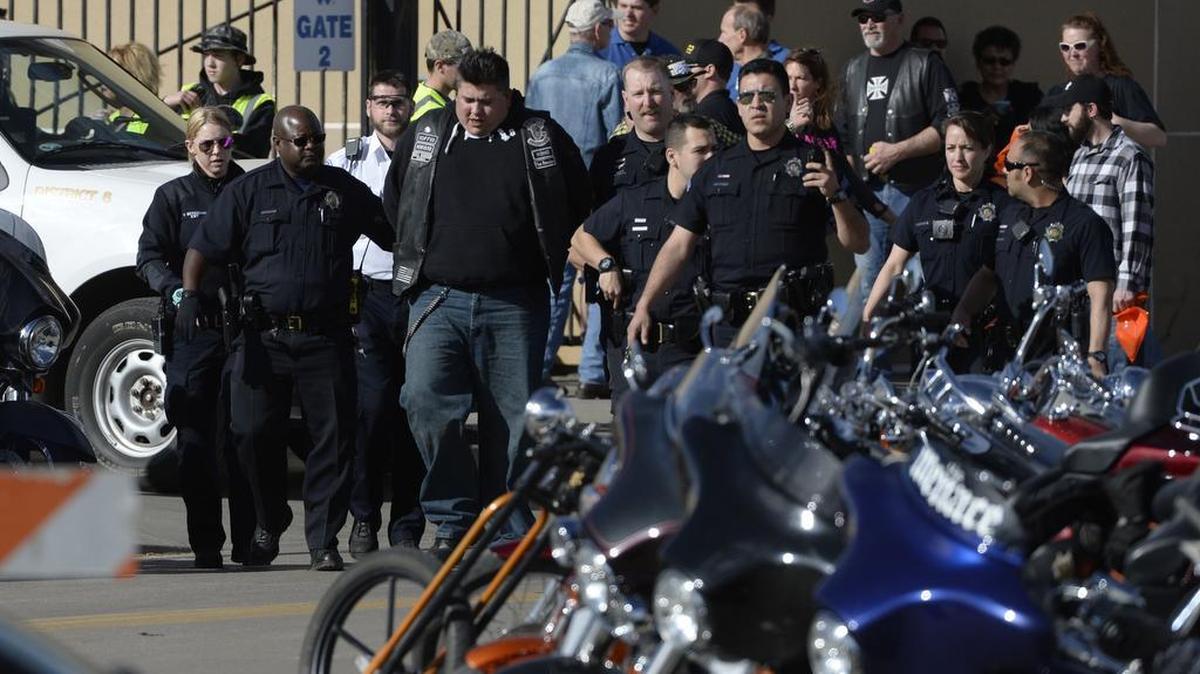 Denver police escort a man in handcuffs away from the National Western Complex on Saturday, Jan. 30, 2016, in Denver.