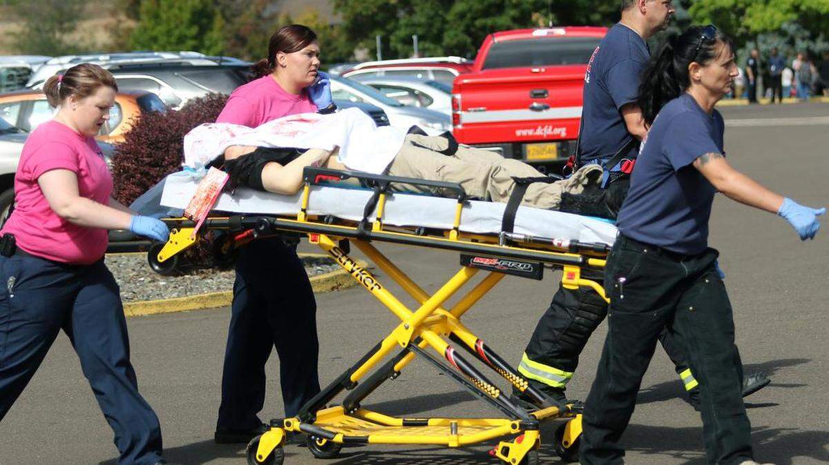 
Authorities carry a shooting victim away from the scene after a gunman opened fire at Umpqua Community College in Roseburg, Ore., Thursday, Oct. 1, 2015. 
