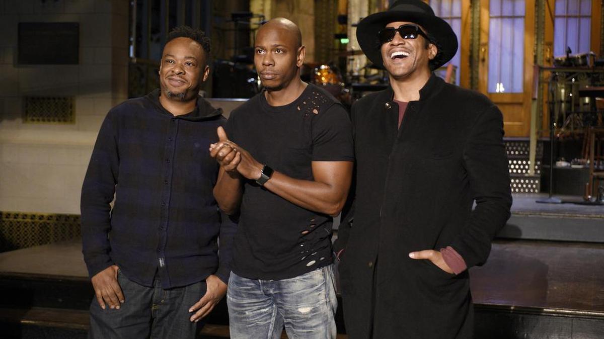 In this Nov. 10, 2016 photo released by NBC, Jarobi White and Q-Tip of musical guest A Tribe Called Quest pose with host Dave Chappelle, center, on the television show, "Saturday Night Live," in New York.