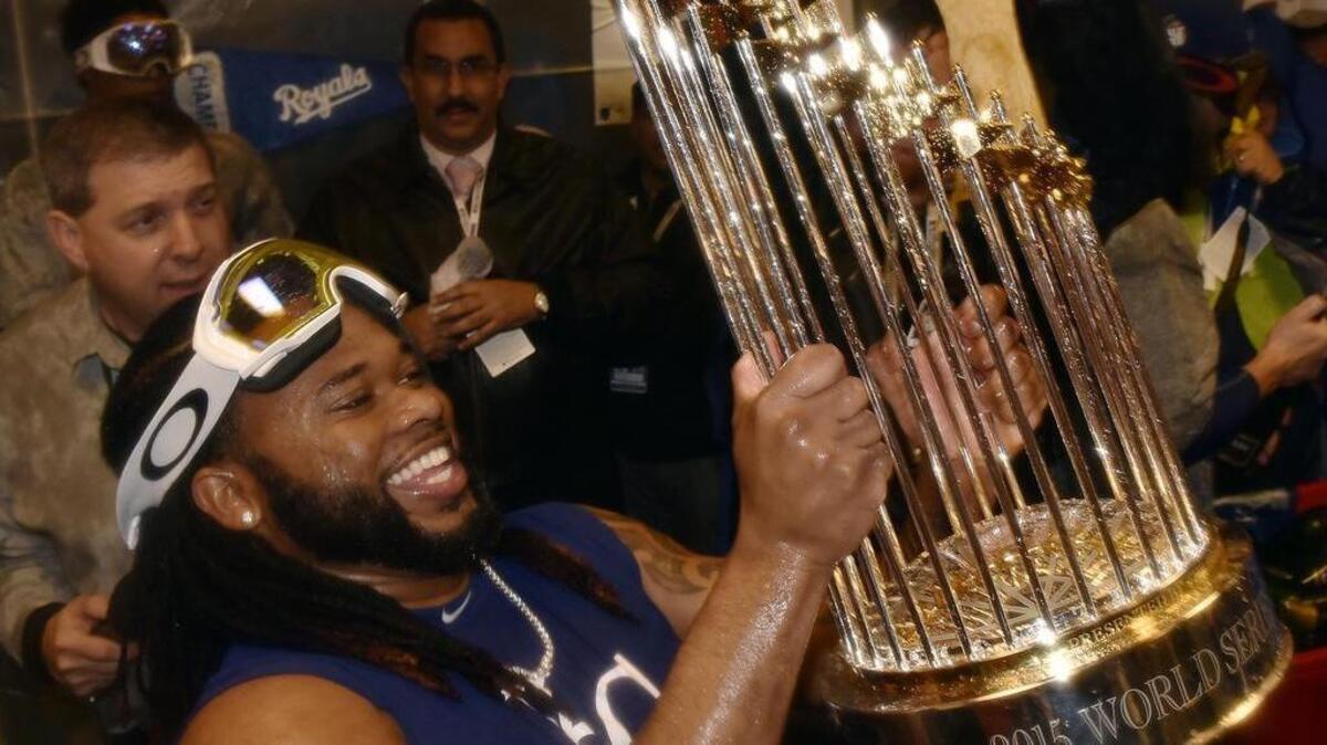 Pitcher Johnny Cueto held the World Series trophy while the rest of the Royals celebrated in the clubhouse after winning the World Series on Sunday.